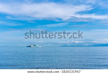 Distant Navy ship on vast blue Pacific Ocean 