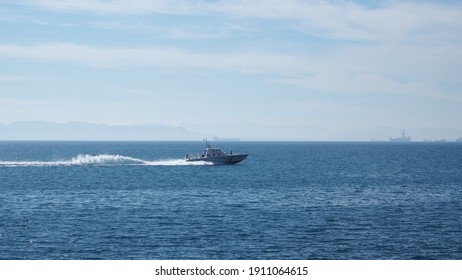 Distant photo of Hellenic coastguard speedboat cruising near port of Piraeus, Attica, Greece