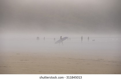 Distant Surfers Foggy Beach