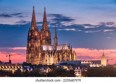 Distant view of the city of Cologne at evening after sunset with the cathedral as an architectural dominant. Real estate and urban life in Germany.