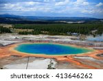 Distant view of the Great Prismatic Spring in Yellowstone National Park with Clouds and Mountains in the background  / Great Prismatic Spring / Great Prismatic Spring in Yellowstone National Park