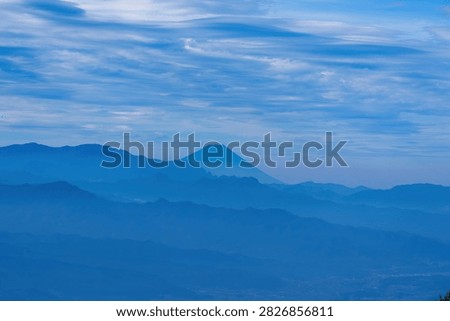 Distant View of Mount Fuji Above Blue Layered Mountain Ranges Under Scenic Clouded Sky seen at Ikenotaira wetland