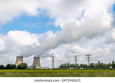 Distant view of an operating nuclear power plant emitting clouds of steam. Concepts of environmental protection and nuclear energy production
