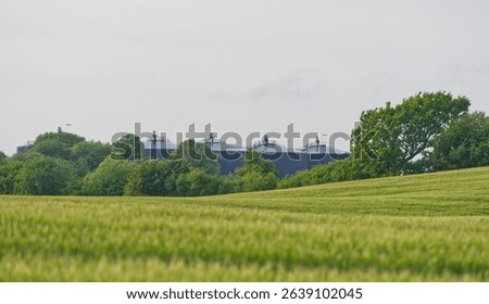 Distant view over fields to the BIO-Gas storage of the biogas site in Kvaers in Denmark also large black barrel-shaped storage