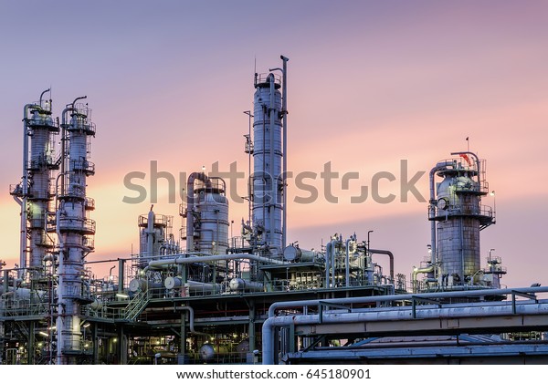 Distillation tower in factory on sky\
sunset background, Closeup of equipment in gas refinery\
plant