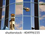 Distorted old tower and crane as reflected in modern windows