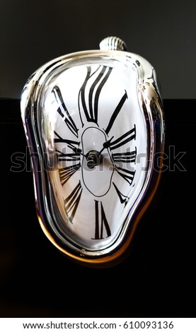 Distorted photograph of a surreal watch over black background. Detail