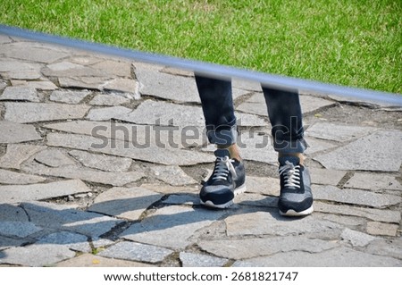 Distorted reflection of legs in a funhouse magic mirror at an amusement park. Humorous and surreal visual effect creating a playful, whimsical scene with warped proportions and mirrored surfaces