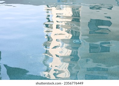 Distorted reflection of the side of a multistorey building in a swimming pool