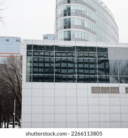 distorted reflection of skyscraper in windows of city building
