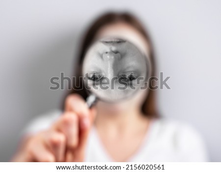 Distorted self perception or image concept. Woman face inverted at magnifying glass. Psychology problems and poor, unstable sense of who you are. High quality photo