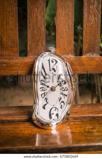 木のベンチにあるゆがんだ柔らかく溶ける時計 ダリの記憶の残り の写真素材 今すぐ編集