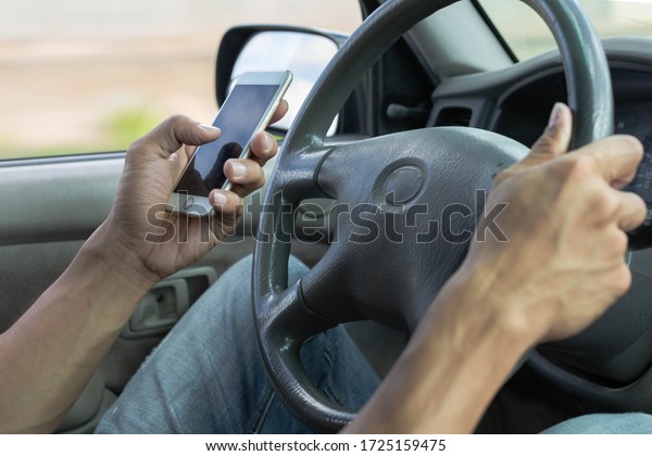 Distracted dangerous driver using a phone in the\
car.  Careless\
driving.