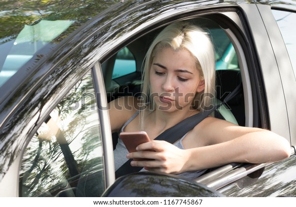 Distracted\
driver reading phone message, driving a\
car