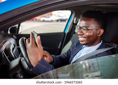 Distracted Driving Can Increase The Chance Of A Road Accident. Portrait Of A Happy Man Texting And Driving In His Car On His Cell Phone. Businessman Using Mobile Phone In The Car