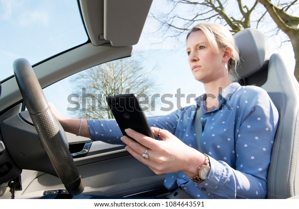 Distracted driving,\
woman texting while\
driving