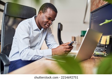 Distracted Employee Looking Using Mobile Phone While Working At Office