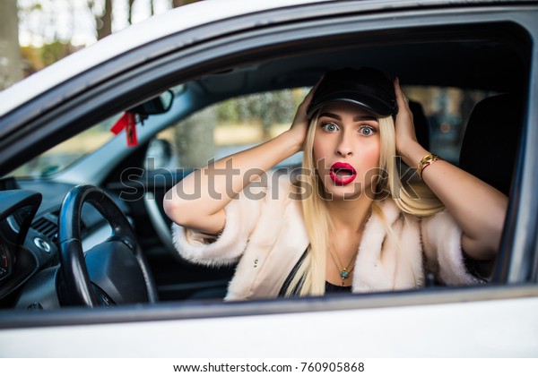 Distracted fright face of a woman driving car,\
wide open mouth eyes holding wheel side window view. Negative human\
face expression emotion reaction. Trip risk danger reckless\
behavior on road\
concept