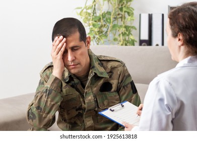 Der hinterhältige amerikanische Soldat hält seinen Kopf in den Händen, während er mit einem Angehörigen der Gesundheitsberufe spricht. 