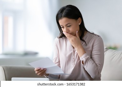 Distressed African American Young Woman Sit On Couch At Home Read Bad Negative News In Paper Correspondence, Unhappy Biracial Female Stressed Consider Unpleasant Message In Postal Letter