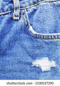 Distressed Ripped Jeans Closeup Photography. Fashion Detail. Trendy Denim Pants In 90s Style