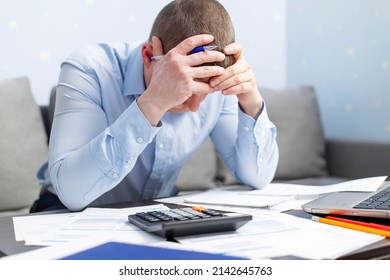 Distressed young man sit at desk paying bills feel stressed having financial problems. Unhappy upset male frustrated by debt or bankruptcy managing household budget or expenses. - Shutterstock ID 2142645763