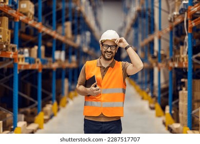 A distribution center manager holds tablet under armpit and greet visitors while smiling at the camera. - Powered by Shutterstock