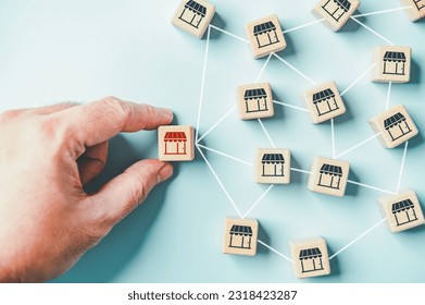 Distribution franchise branch store. Hand placing red franchising shop cube wooden toy block business partner alliance network icon symbol. Market growth expansion financial loan marketing. Copy space