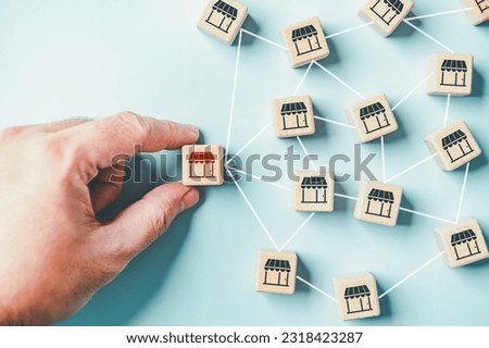 Distribution franchise branch store. Hand placing red franchising shop cube wooden toy block business partner alliance network icon symbol. Market growth expansion financial loan marketing. Copy space