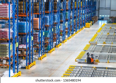 Distribution warehouse interior. Top view of large storage area with goods on the shelf and forklifts.