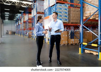 Distribution warehouse manager and client businesswoman using digital tablet checking inventory storage on shelf. Storehouse supervisor worker and logistic engineer standing together at storage room. - Powered by Shutterstock