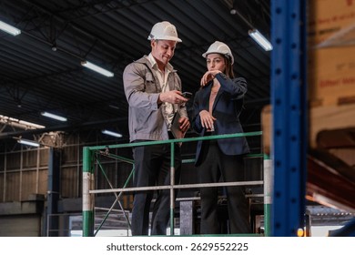 Distribution warehouse manager and client businesswoman using digital tablet checking inventory storage on shelf. Storehouse business worker and logistic engineer standing together at storage service