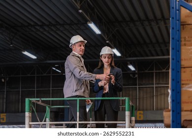 Distribution warehouse manager and client businesswoman using digital tablet checking inventory storage on shelf. Storehouse business worker and logistic engineer standing together at storage service