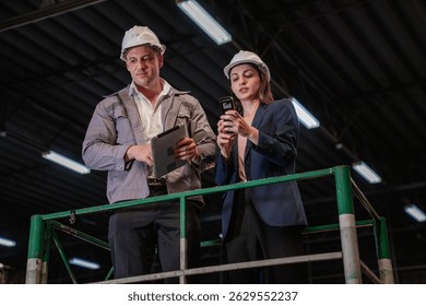 Distribution warehouse manager and client businesswoman using digital tablet checking inventory storage on shelf. Storehouse business worker and logistic engineer standing together at storage service