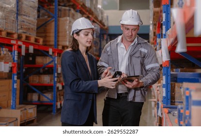 Distribution warehouse manager and client businesswoman using digital tablet checking inventory storage on shelf. Storehouse business worker and logistic engineer standing together at storage service