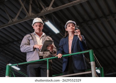 Distribution warehouse manager and client businesswoman using digital tablet checking inventory storage on shelf. Storehouse business worker and logistic engineer standing together at storage service