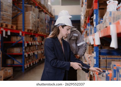 Distribution warehouse manager and client businesswoman using digital tablet checking inventory storage on shelf. Storehouse business worker and logistic engineer standing together at storage service