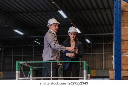 Distribution warehouse manager and client businesswoman using digital tablet checking inventory storage on shelf. Storehouse business worker and logistic engineer standing together at storage service