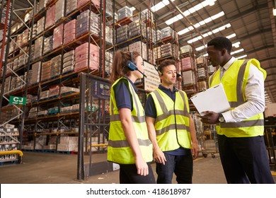 Distribution warehouse manager in discussion with colleagues