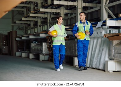 Distribution Warehouse Workers Talking While Walking Through Storage Room During Their Coffee Break. Copy Space. 