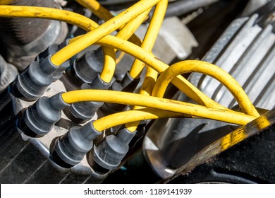 Distributor Cap And High Performance Yellow Ignition Wires On A Car Engine.