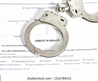 District Court Arrest Warrant court papers with handcuffs isolated on white with shallow depth of field