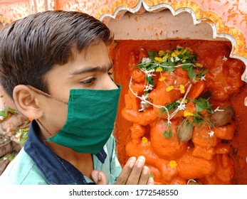 District Katni, Madhya Pradesh, India  - July 08, 2020: An Indian Boy Wearing Green Color Face Mask At Hindu Temple During Worship For Corona Virus Protection. 