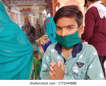 District Katni, Madhya Pradesh, India  - July 08, 2020: An Indian Little Boy Wearing Green Color Facemask At Hindu Temple During Worship For Corona Virus Protection. 