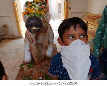 District Katni, Madhya Pradesh, India - July 08, 2020: An Indian Cute Village Boy Wearing Face Mask At Lord Shiva Temple During Worship For Corona Virus Protection. 