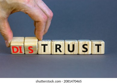 Distrust Or Trust Symbol. Businessman Turns Wooden Cubes, Changes Words 'distrust' To 'trust'. Beautiful Grey Table, Grey Background. Business And Distrust Or Trust Concept, Copy Space.