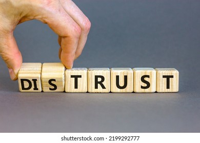 Distrust Or Trust Symbol. Businessman Turns Wooden Cubes, Changes Words 'distrust' To 'trust'. Beautiful Grey Table, Grey Background. Business And Distrust Or Trust Concept, Copy Space.