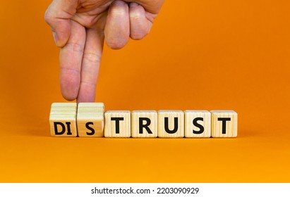 Distrust Or Trust Symbol. Businessman Turns Wooden Cubes, Changes Words 'distrust' To 'trust'. Beautiful Orange Table, Orange Background. Business And Distrust Or Trust Concept, Copy Space.