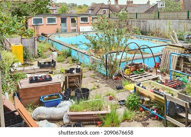 Disused Swimming Pool, Becoming Overgrown With Weeds, With Run Down Equipment And Changing Rooms