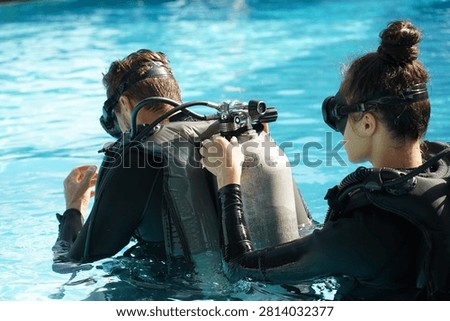 Dive instructor checking novice the diving equipment before diving